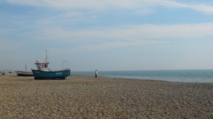 Aldeburgh beach with boat and man staring out to sea